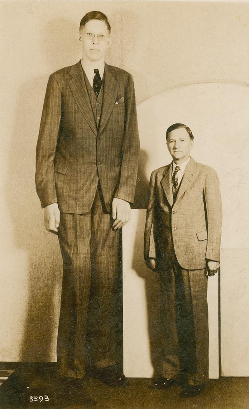 Historical image of Robert Wadlow next to his father.