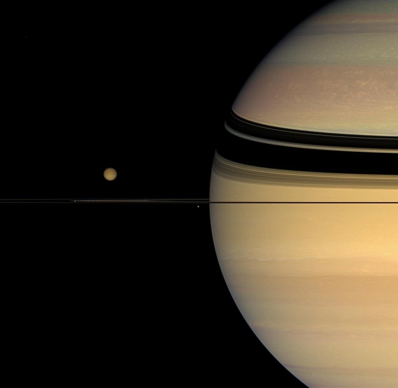 Saturn with its moons and rings in the background