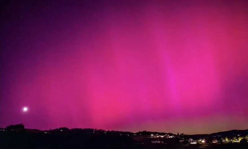 Purple auroras glowing over the Austrian countryside